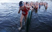 Swimmers emerge from the Serpentine river on Christmas Day in Hyde Park, central London December 25, 2013. For over 100 years, swimmers have taken part in the Christmas Day "Peter Pan" swim in the Serpentine. REUTERS/Suzanne Plunkett (BRITAIN - Tags: SOCIETY SPORT SWIMMING TPX IMAGES OF THE DAY)