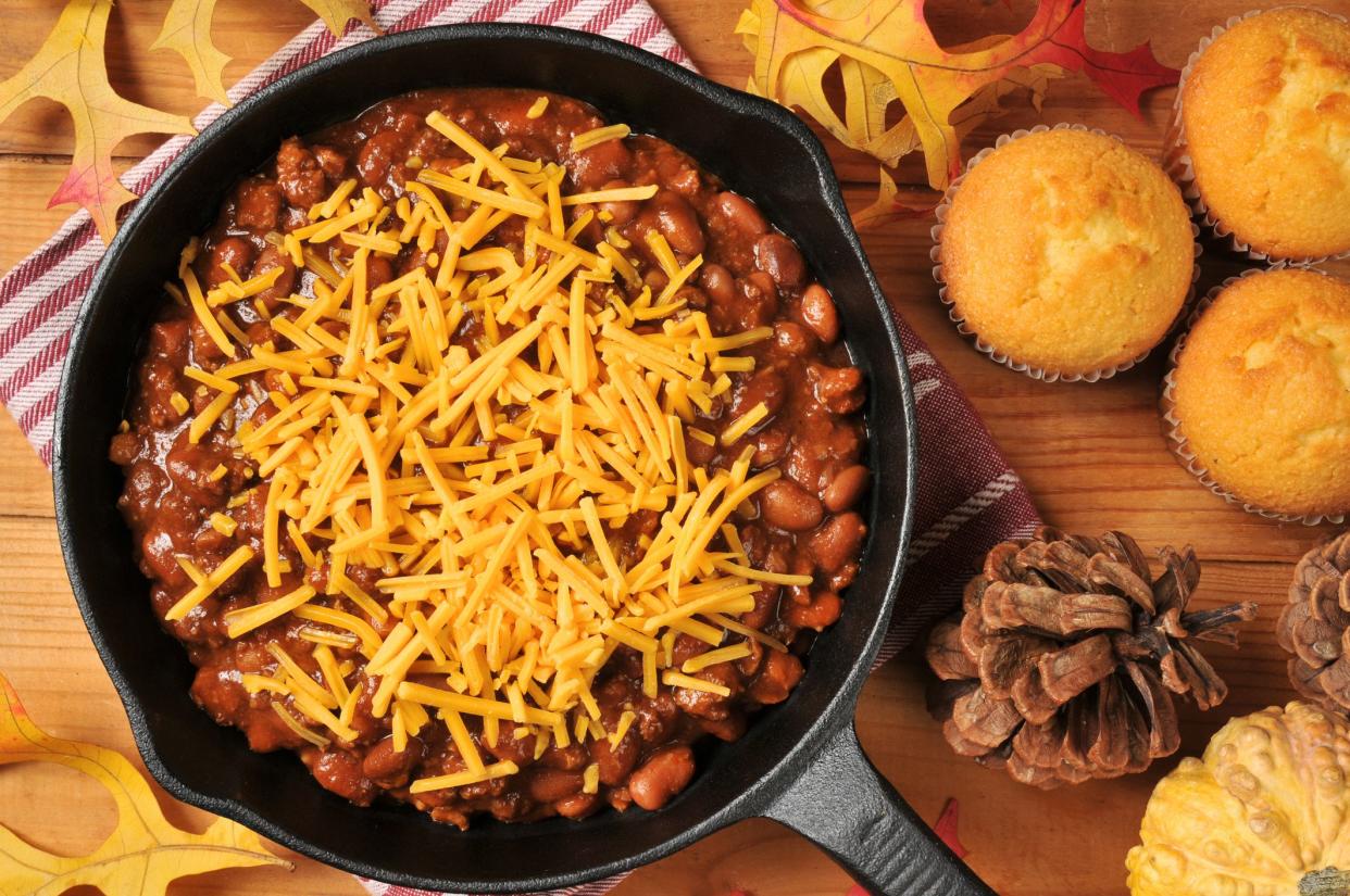 A cast iron skilled with chili con carne and cheddar cheese, from a high angle view
