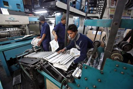 Employees sort Dainik Jagran newspapers inside its printing press in Noida, on the outskirts of New Delhi February 25, 2014. REUTERS/Anindito Mukherjee