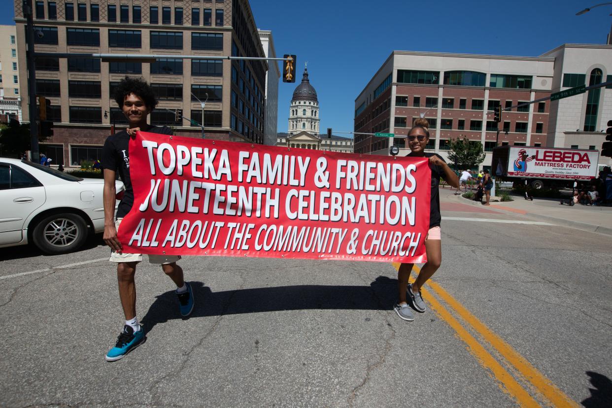Banners signifying this year's Juneteenth parade will lead the way through downtown Topeka streets Saturday.