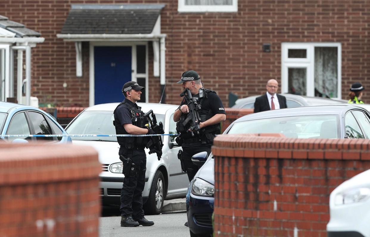 Manchester attack: Armed police at a cordon in Quantock Street, Moss Side, as fresh arrests and raids are carried out linked to suicide bombing: PA