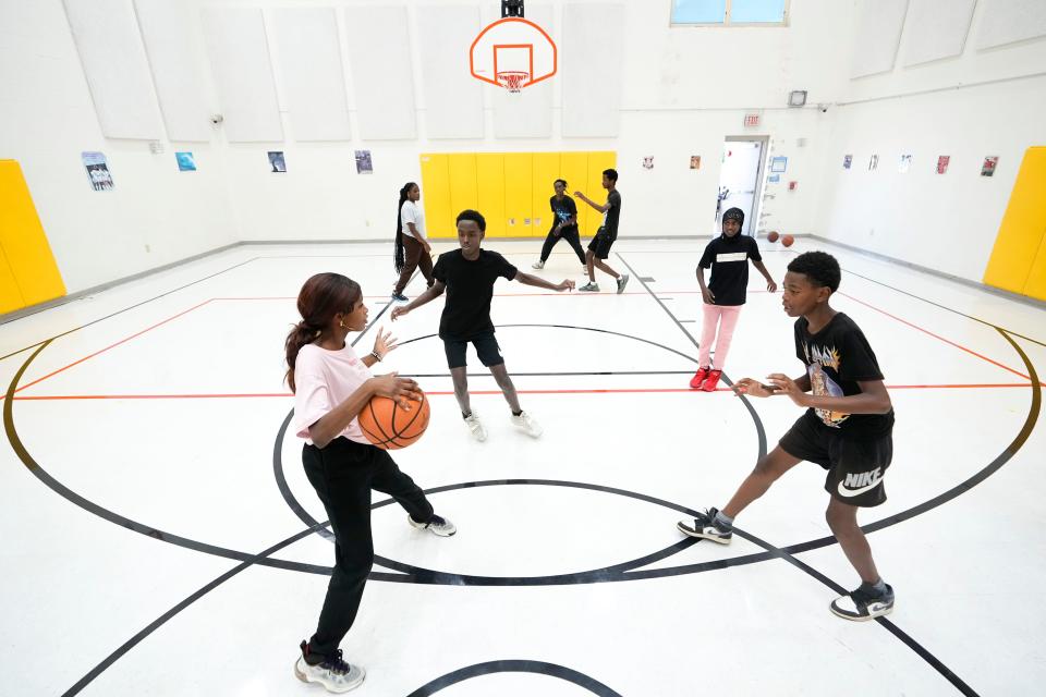 Asha Mohamed, 14, from left, tries to dribble between Saleh Abdulkadir, 15, and Abdirisaka Sidaw, 15, during a Neighborhood Athletics basketball practice Tuesday at Sullivant Elementary on the West Side. Neighborhood Athletics is a nonprofit founded by Somali Bantu volunteers that offers coaching in a basketball and soccer for elementary through high school kids.