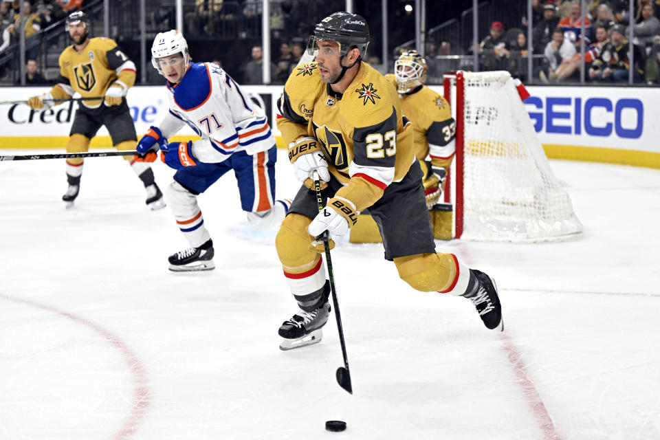 Vegas Golden Knights defenseman Alec Martinez (23) looks to clear the puck against the Edmonton Oilers during the first period of an NHL hockey game Tuesday, Feb. 6, 2024, in Las Vegas. (AP Photo/David Becker)