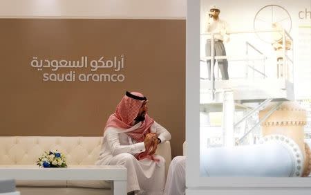 A Saudi Aramco employee sits in the area of its stand at the Middle East Petrotech 2016, an exhibition and conference for the refining and petrochemical industries, in Manama, Bahrain, September 27, 2016. REUTERS/Hamad I Mohammed/File Photo