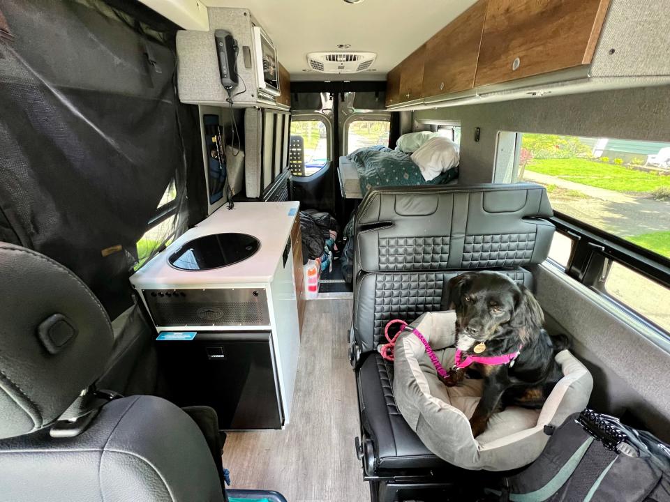 the inside of ashley probst sprinter van, dog on cushion on lower right side