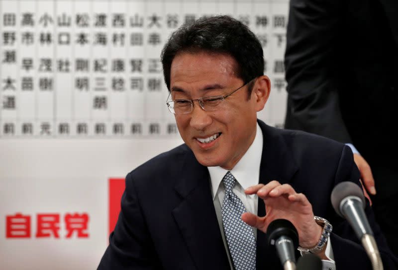 Japan's ruling Liberal Democratic Party policy chief Fumio Kishida smiles as he speaks with the media after Japan's lower house election at the LDP headquarters in Tokyo