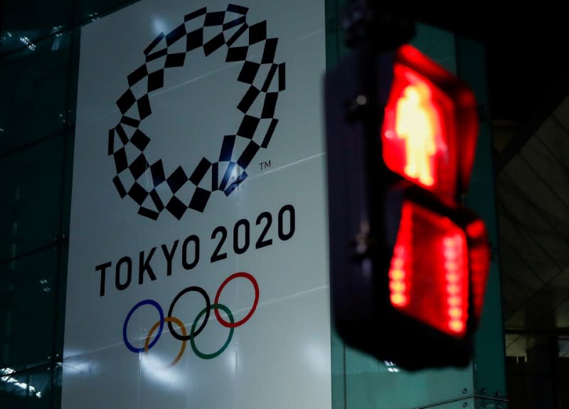FILE PHOTO : A banner for the upcoming Tokyo 2020 Olympics is seen through a traffic signal in Tokyo