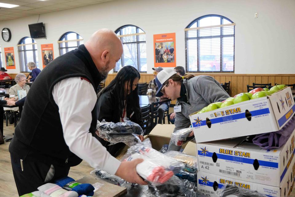 Members of the Salvation Army of Amarillo load up donated socks Tuesday  from United Supermarkets' Pears for Pairs program in Amarillo.