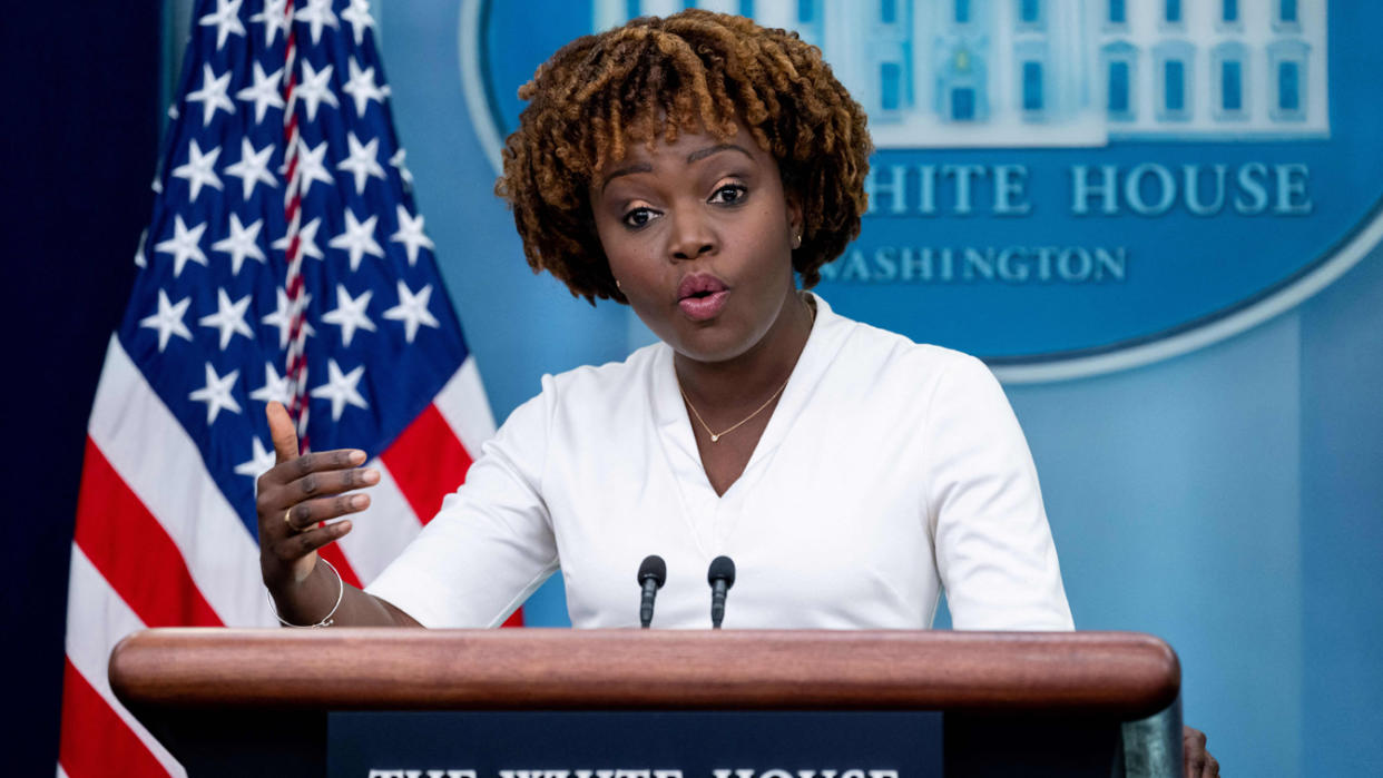 Press secretary Karine Jean-Pierre at the podium with the White House Seal and an American flag behind her.