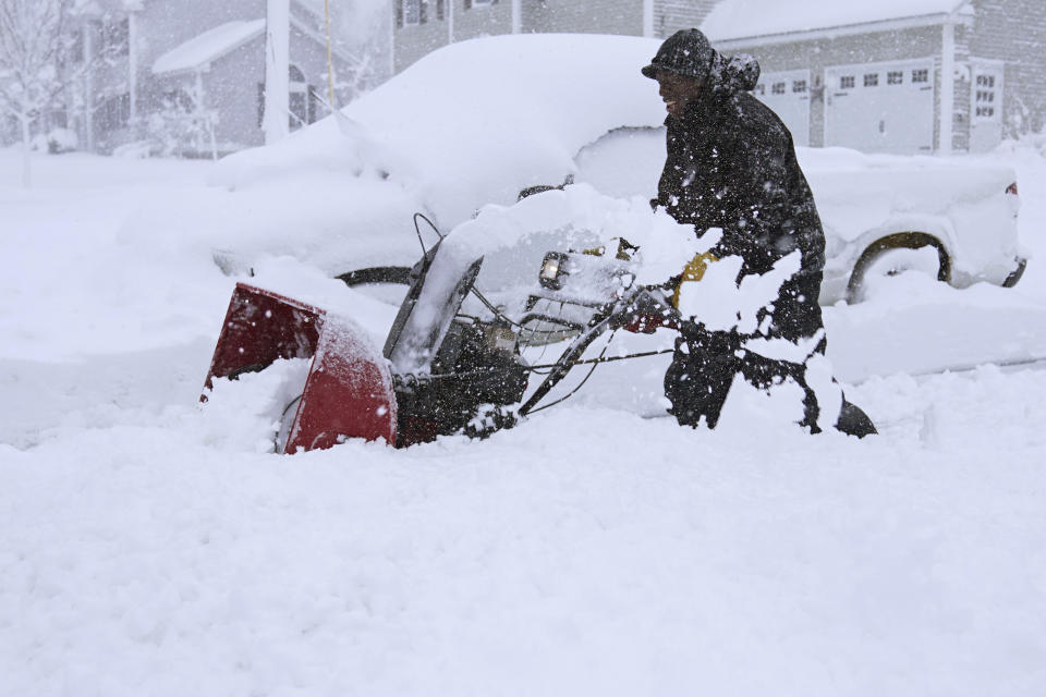 Darrin Davis clears his driveway, Tuesday, March 14, 2023, in East Derry, N.H. By the time the winter storm wraps up Wednesday, snow totals in New England are expected to reach a couple of feet of snow in higher elevations to several inches along the coast. (AP Photo/Charles Krupa)