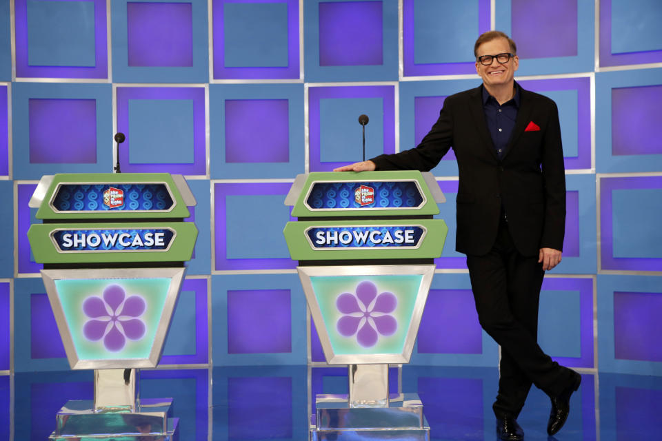 This 2013 photo released by CBS shows Drew Carey, host of "The Price is Right," on the set in Los Angeles. On Tuesday, April 7, the game show will air its 8,000th episode since it debuted on CBS in 1972. The concept hasn't changed through the years and it's a nonstop party in the hands of host Drew Carey. (AP Photo/CBS, Cliff Lipson)