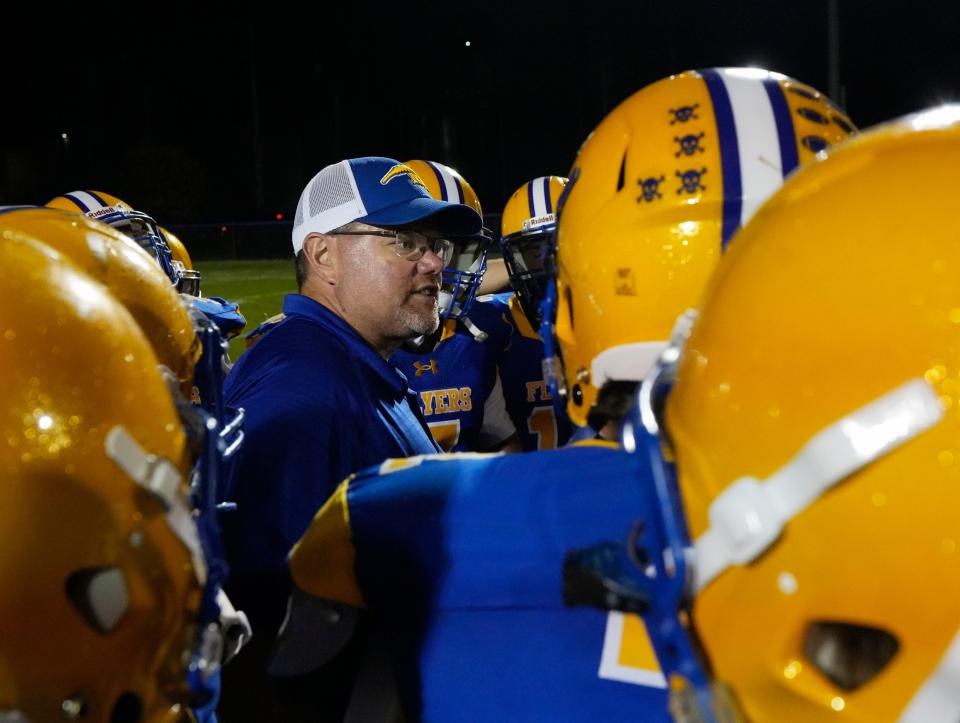 Marion Local football coach Tim Goodwin talks with his players following a 14-13 win over Versailles on Sept. 22.