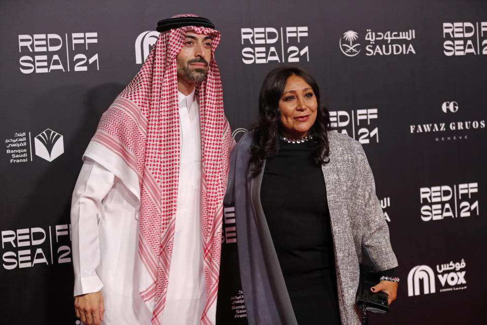 Red Sea International Film Festival Chairman Mohammed Al-Turki, left, and Saudi filmmaker Haifa al-Mansour pose for photographers on the red carpet during the opening of the first edition of the festival, in Jiddah, Saudi Arabia, late Monday, Dec. 6, 2021. Saudi Arabia is holding its first ever film festival three and-a-half years after the first movie premiered in cinemas in the kingdom. The festival featured a red carpet with women in floor-length ball gowns, a stark departure from past years when females had to wear the long flowing robe known as the abaya in public. (AP Photo/Amr Nabil)