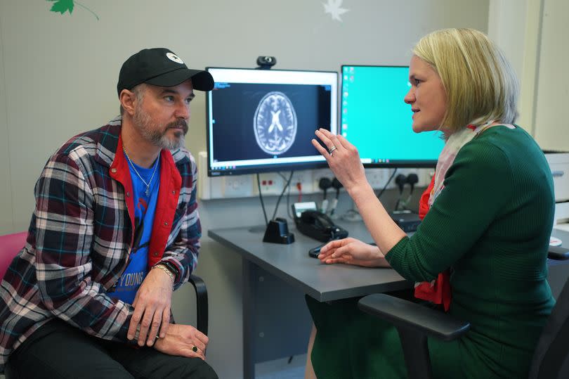 Consultant Dr Heather Shaw speaking to patient Steve Young, with an MRI of his brain on the screen, during a consultation at University College Hospital Macmillan Cancer Centre in London