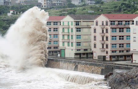 A wave, under the influence of Typhoon Chan-hom, hits the shore next to residential buildings in Wenling, Zhejiang province, China, July 10, 2015. REUTERS/Stringer