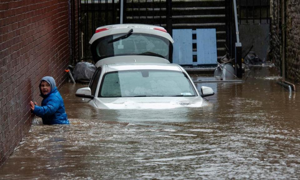 A boy wades through a flooded alleyway in Pontypridd.