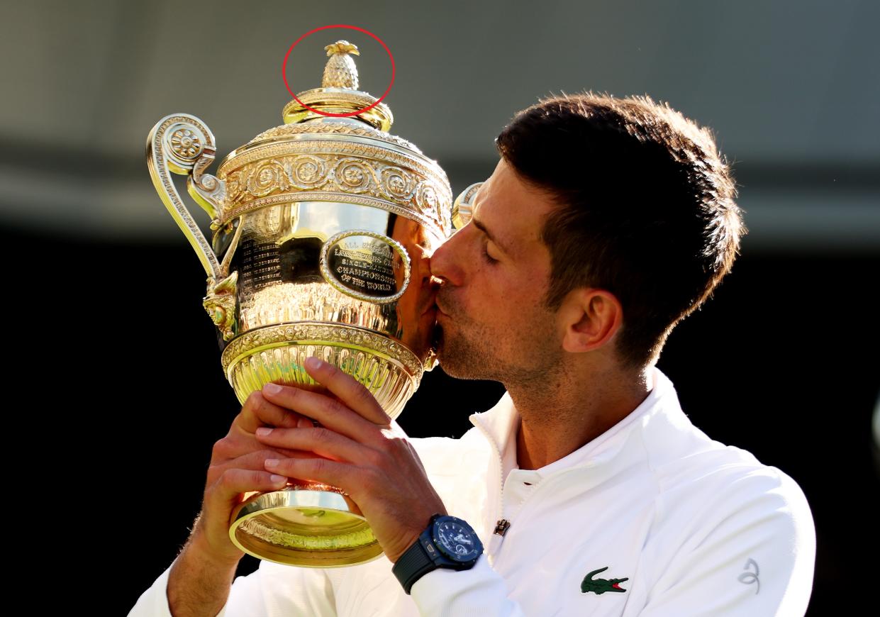 Novak Djokovic besando el trofeo de campeón de Wimbledon, que tiene una piña en su parte superior. (Foto: Clive Brunskill / Getty Images).