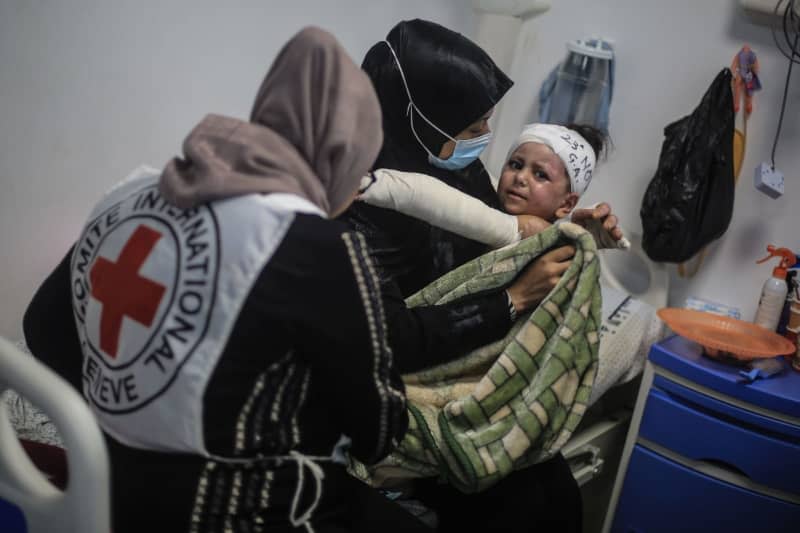 A member of the International Committee of the Red Cross sits next to an injured child at the European Hospital in Khan Yunis, amid the ongoing conflict between Israel and the Palestinian militant group Hamas. The World Health Organization (WHO) said that emergency situation forces numerous unnecessary amputations in the Gaza Strip even though the limbs could be saved. Mohammed Talatene/dpa