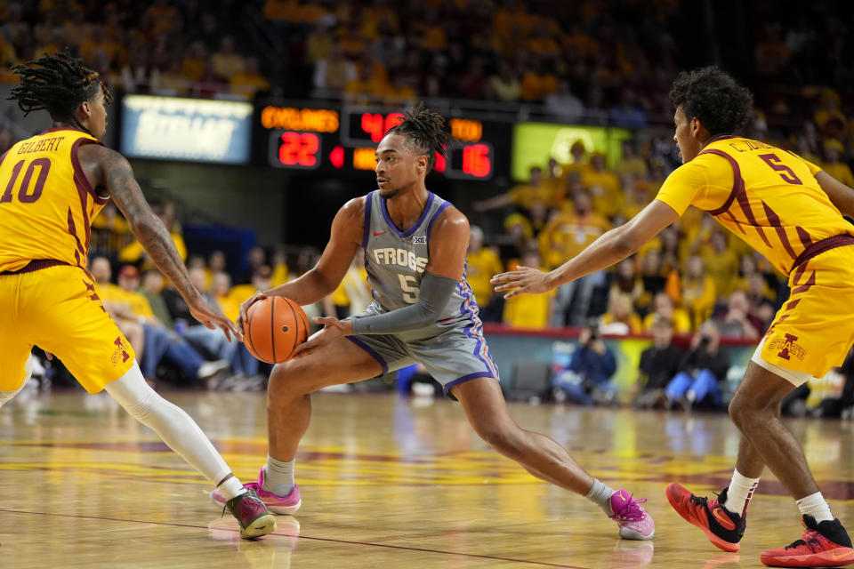 TCU forward Chuck O'Bannon Jr., center, drives between Iowa State guard Keshon Gilbert (10) and guard Curtis Jones, right, during the first half of an NCAA college basketball game, Saturday, Feb. 10, 2024, in Ames, Iowa. (AP Photo/Charlie Neibergall)