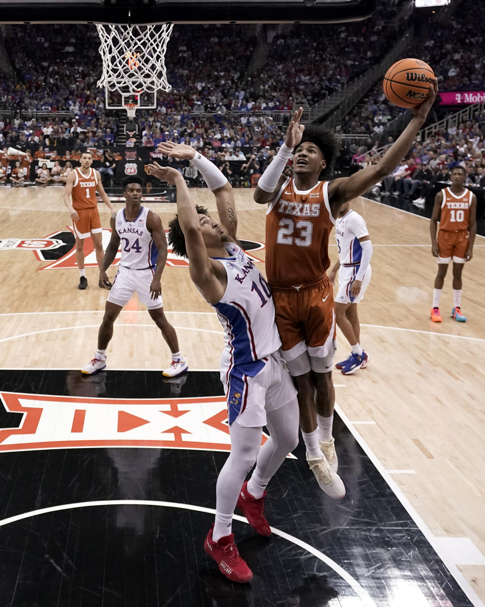 Texas forward Dillon Mitchell (23) shoots over Kansas forward Jalen Wilson (10) during the first half of the NCAA college basketball championship game of the Big 12 Conference tournament Saturday, March 11, 2023, in Kansas City, Mo. (AP Photo/Charlie Riedel)