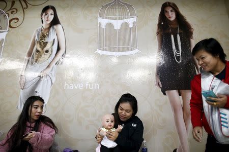 A devotee dresses up her "child angel" doll inside a department store in Bangkok, Thailand, January 26, 2016. REUTERS/Athit Perawongmetha