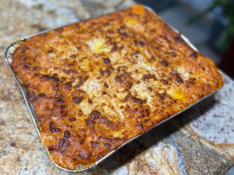 pan of cooked lasagna with browned cheese on top on a kitchen counter