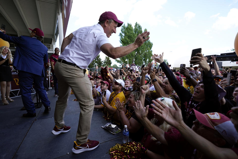 Josh Harris, the leader of a group buying the Washington Commanders, high-fives fans during an NFL football pep rally at FedEx Field in Landover, Md., Friday, July 21, 2023. (AP Photo/Alex Brandon)