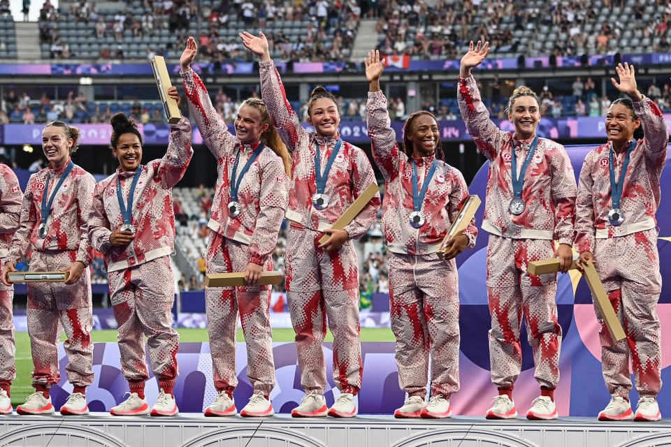 Canada's players celebrate with their silver medals on the podium during the victory ceremony following the women's gold medal rugby sevens match between New Zealand and Canada during the Paris 2024 Olympic Games at the Stade de France in Saint-Denis on July 30, 2024. (Photo by CARL DE SOUZA / AFP) (Photo by CARL DE SOUZA/AFP via Getty Images)