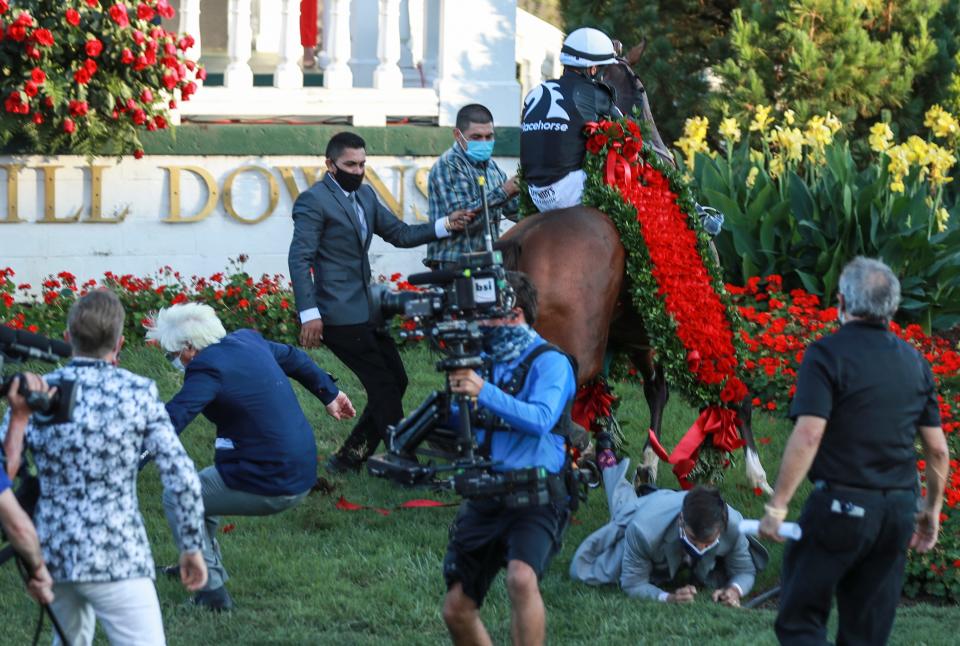 Trainer Bob Baffert, left, got knocked down as well as another man  by a jittery Authentic as jockey John Velazquez tries to calm the horse after winning the 2020 Kentucky Derby at Churchill Downs.  Sept. 5, 2020