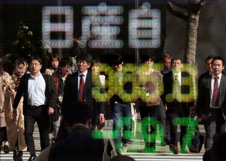 FILE PHOTO - People are reflected in a stock quotation board showing share price of Nissan Motor Co outside a brokerage in Tokyo, Japan November 20, 2018. REUTERS/Toru Hanai