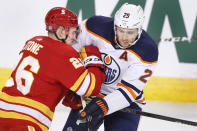 Calgary Flames' Michael Stone, left, runs into Edmonton Oilers' Leon Draisaitl during the first period of an NHL hockey game Saturday, April 10, 2021, in Calgary, Alberta. (Larry MacDougal/The Canadian Press via AP)