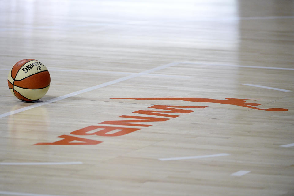 A basketball lies near a WNBA logo on the court during the second half of a WNBA basketball first round playoff game between the Chicago Sky and the Connecticut Sun, Tuesday, Sept. 15, 2020, in Bradenton, Fla. (AP Photo/Phelan M. Ebenhack)
