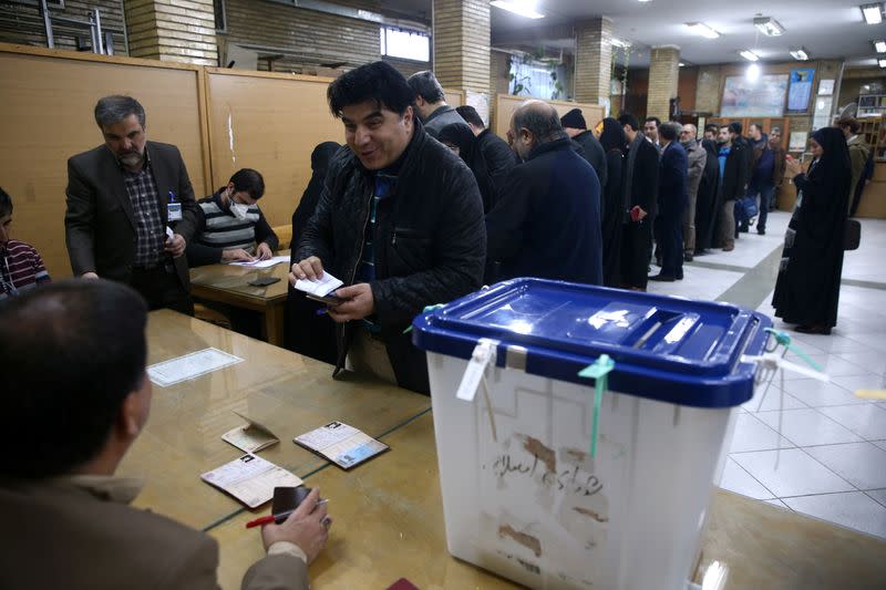 Iranians line up before they cast their vote during parliamentary elections at a polling station in Tehran