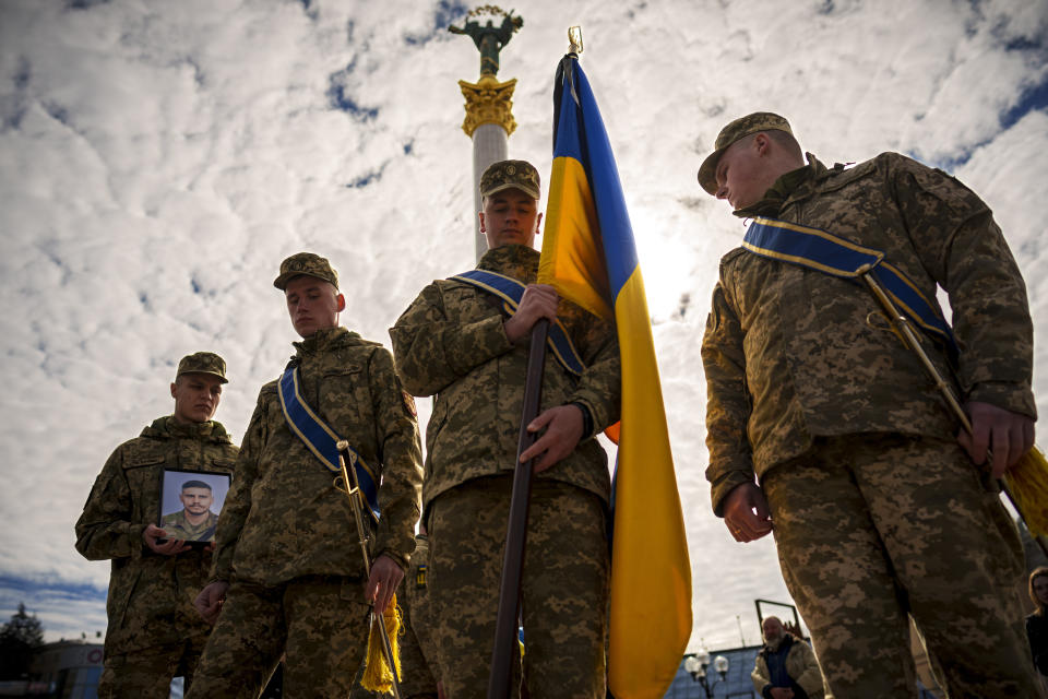 Ukrainian servicemen walk ahead of the coffin of their fallen fellow Vadym Popelniuk, born in 1991, carrying his photograph during a religious service in Independence Square in Kyiv, Ukraine, Friday, April 5, 2024. (AP Photo/Vadim Ghirda)