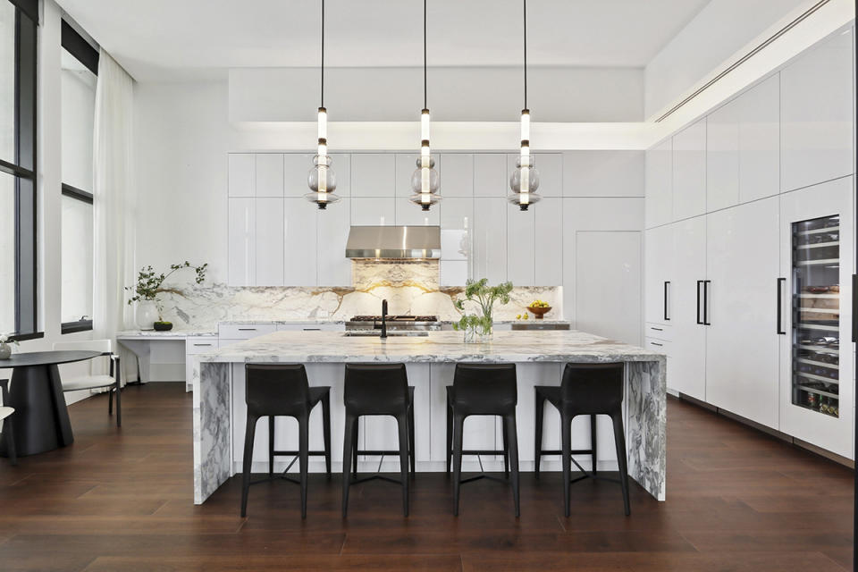 Sleek laminated cabinetry and the book-matched stone backsplash are highlights of the kitchen.