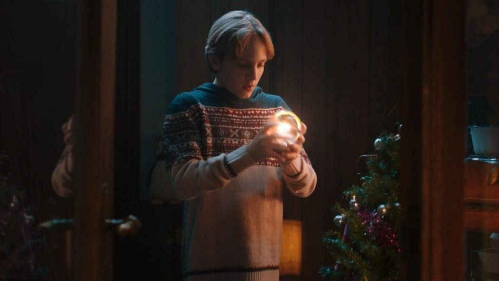 a boy stares incredulously at a glowing orb in a scene from the claus family, a good housekeeping pick for best christmas movies for kids