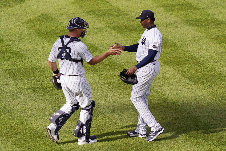 New York Yankees catcher Erik Kratz, left, shakes hands with relief pitcher Aroldis Chapman after Chapman earned a save in a victory over the Baltimore Orioles in a baseball game, Sunday, Sept. 13, 2020, at Yankee Stadium in New York. (AP Photo/Kathy Willens)
