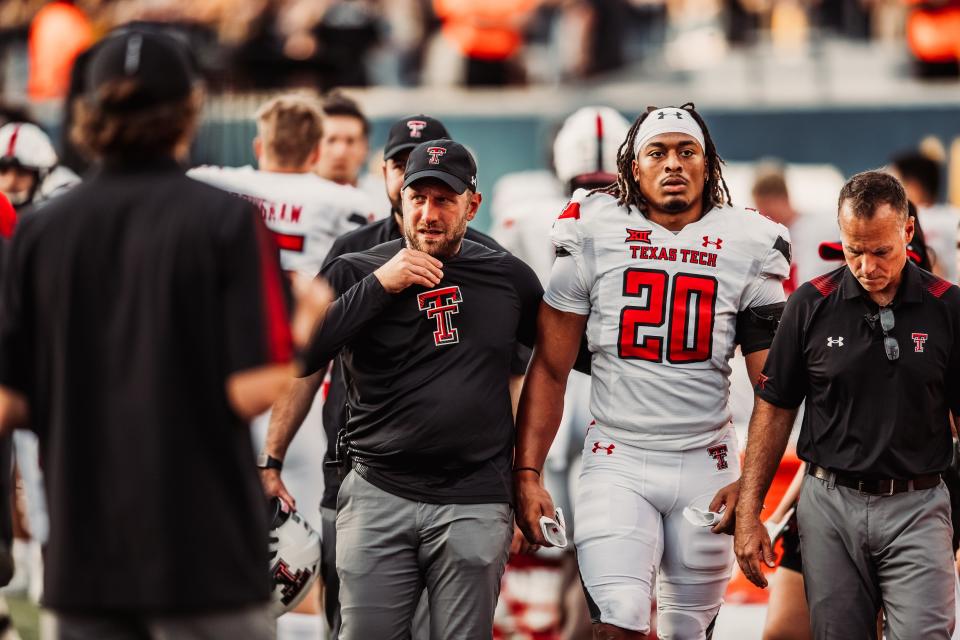Texas Tech head athletic trainer Drew Krueger, left, and team physician Dr. Michael Phy, right, escort linebacker Kosi Eldridge off the field during a game at West Virginia. The Arizona Cardinals have hired Krueger, a Red Raiders staff member for nine years, Tech announced Friday.
(Photo: ELISE BRESSLER/TEXAS TECH ATHLETICS)