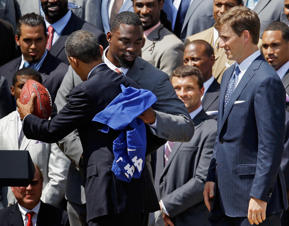 WASHINGTON, DC - JUNE 08: U.S. President Barack Obama New York Giants player Justin Tuck as quarterback Eli Manning looks on during a ceremony for the National Football League Super Bowl champions at the White House June 8, 2012 in Washington, DC. The Giants defeated The New England Patriots 21-17 to win Super Bowl XXXXVI. (Photo by Chip Somodevilla/Getty Images)