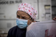 A healthcare worker protests against plans by Madrid's authorities to force staff to transfer to other hospitals at La Paz hospital in Madrid, Spain, Friday, Jan. 22, 2021. Virus infections have been increasing steeply following Christmas and New Year, putting pressure on Spain's public health system. (AP Photo/Manu Fernandez)