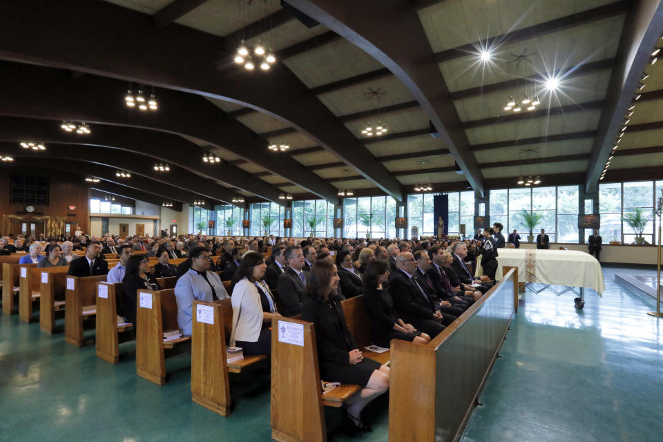 Mourners attend the funeral for Evelyn Rodriguez, at Saint Anne's Roman Catholic Church, in Brentwood, N.Y., Friday, Sept. 21, 2018. Rodriguez, 50, is a mother recognized by President Donald Trump for turning grief over her daughter's suspected gang killing into a crusade against MS-13. She was struck and killed by an SUV on Sept. 14 after a heated confrontation with the driver over the placement of a memorial to her slain daughter, Kayla Cuevas. (AP Photo/Richard Drew)