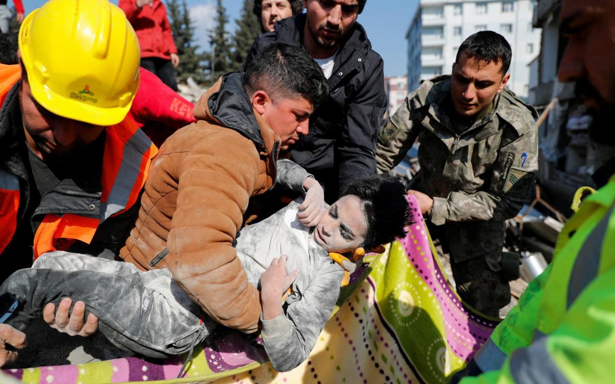 Rescuers carry Syrian boy Mehtez farac, 8, who survived after he was pulled from the rubble - KEMAL ASLAN
