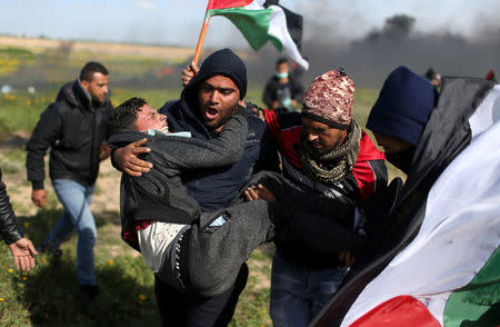 A wounded Palestinian is evacuated during clashes with Israeli troops at a protest against Trump's decision on Jerusalem, near the border with Israel in the southern Gaza Strip March 9, 2018. REUTERS/Ibraheem Abu Mustafa
