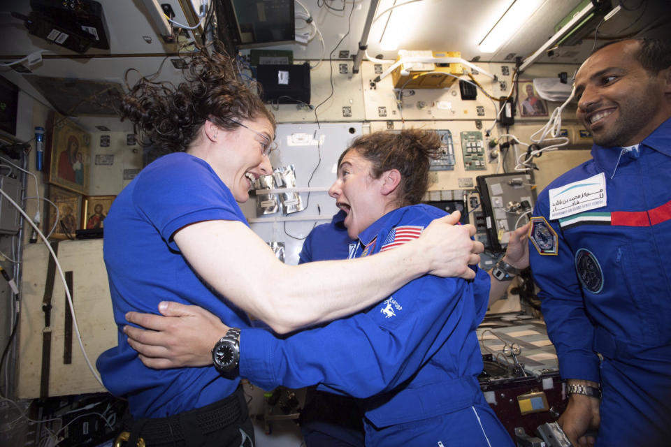 In this photo made available by NASA astronaut Jessica Meir on Sept. 29, 2019, Christina H. Koch, left, and Meir greet each other after Meir's arrival on the International Space Station. On Friday, Sept. 4, 2019, NASA announced that the International Space Station’s two women will pair up for a spacewalk on Oct. 21 to plug in new batteries. (NASA via AP)