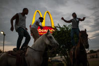 <p>A group of young cowboys dance atop their horses outside McDonald’s in Cleveland, Miss., August 2017. (Photograph by Rory Doyle) </p>