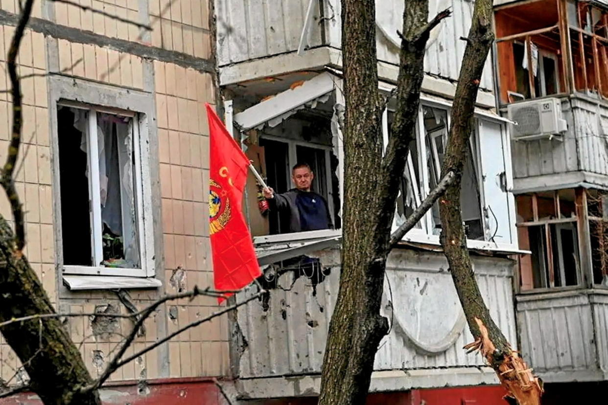 Un habitant de Belgorod brandit un drapeau depuis un bâtiment endommagé à la suite d’un bombardement, le 16 mars.  - Credit:EPA/MAXPPP