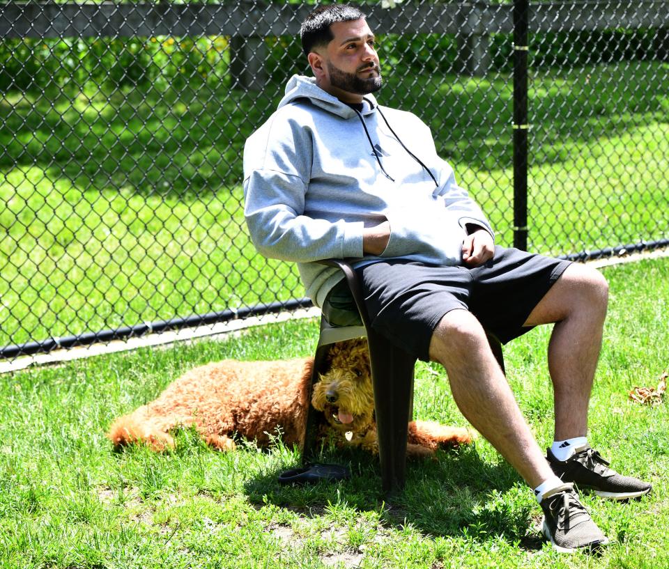 Hoselito "Oli" Rapi's dog, Bella, gets some shade under his chair at Beaver Brook dog park.