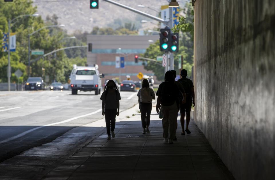 UC Riverside students walk the mile back to campus under the 60 freeway after attending class off campus.