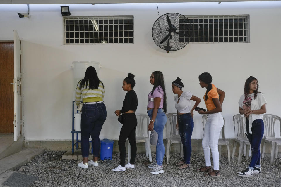 Patients wait their turn to enter a Doctors without Borders medical clinic in Putucual, Venezuela, Wednesday, Jan. 10, 2024. The women and teenage girls came to the medical clinic in eastern Venezuela for free contraceptives where a community health worker taught them how to use an IUD, condoms and birth control pills correctly and about HPV infections. (AP Photo/Matias Delacroix)