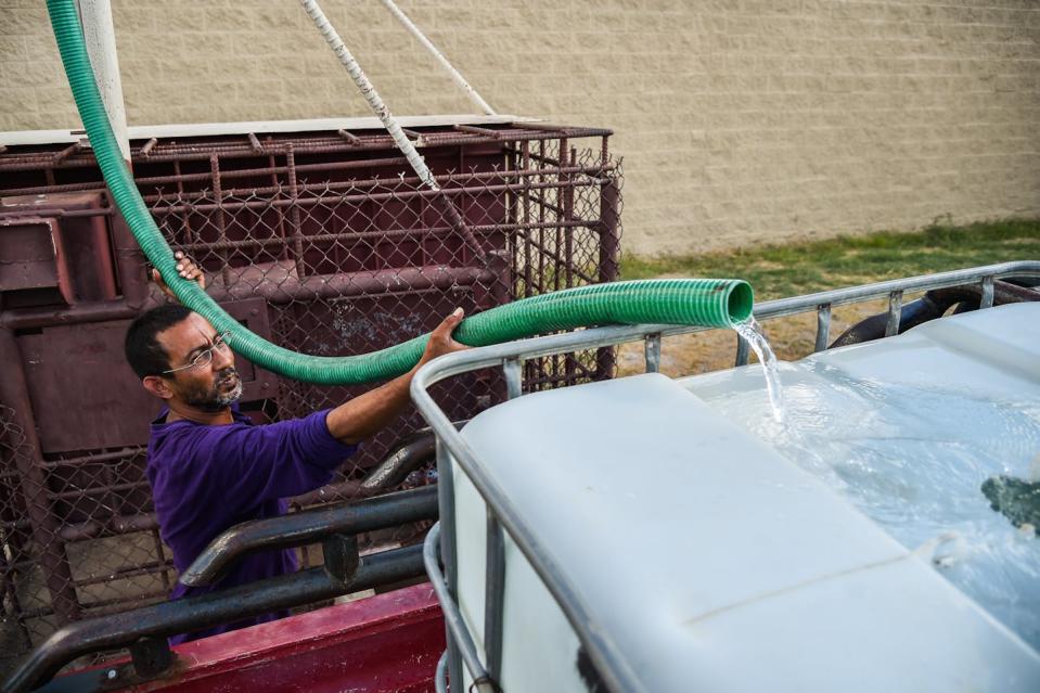 A U.S. Army veteran fills a tank in the back of his pickup with water in Laredo, Texas, to provide water for his mother’s home. Rural residents in parts of the Southwest have to truck in clean water. <a href="https://www.gettyimages.com/detail/news-photo/carlos-salas-u-s-army-veteran-fills-his-water-tank-that-is-news-photo/916823510" rel="nofollow noopener" target="_blank" data-ylk="slk:Salwan Georges/The Washington Post via Getty Images;elm:context_link;itc:0" class="link ">Salwan Georges/The Washington Post via Getty Images</a>